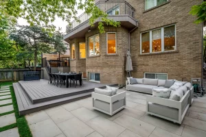 Custom composite deck connected to a stone patio and outdoor lounge area