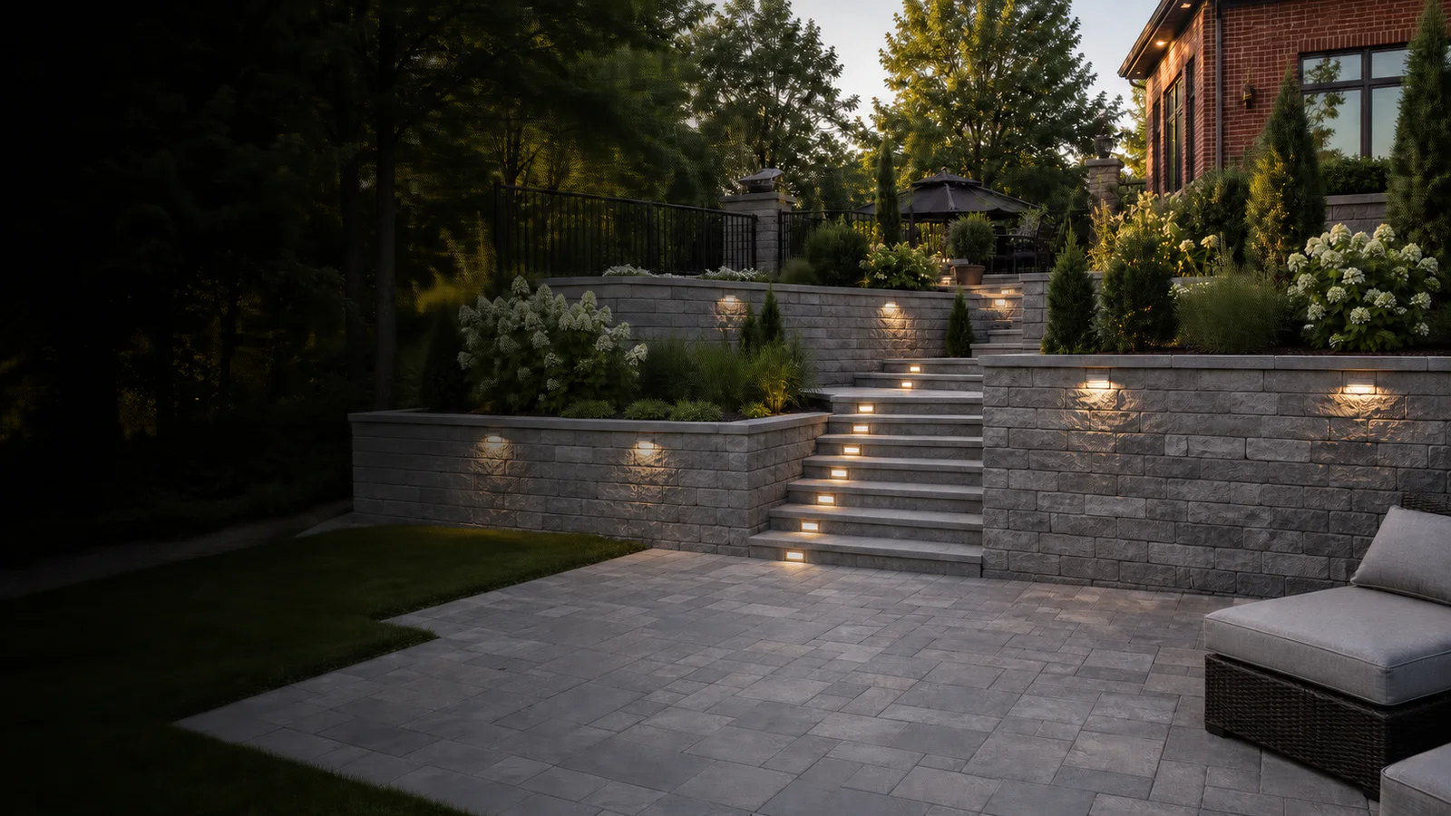 Terraced segmental retaining walls with broad steps, lighting and planted beds at a Toronto brick home