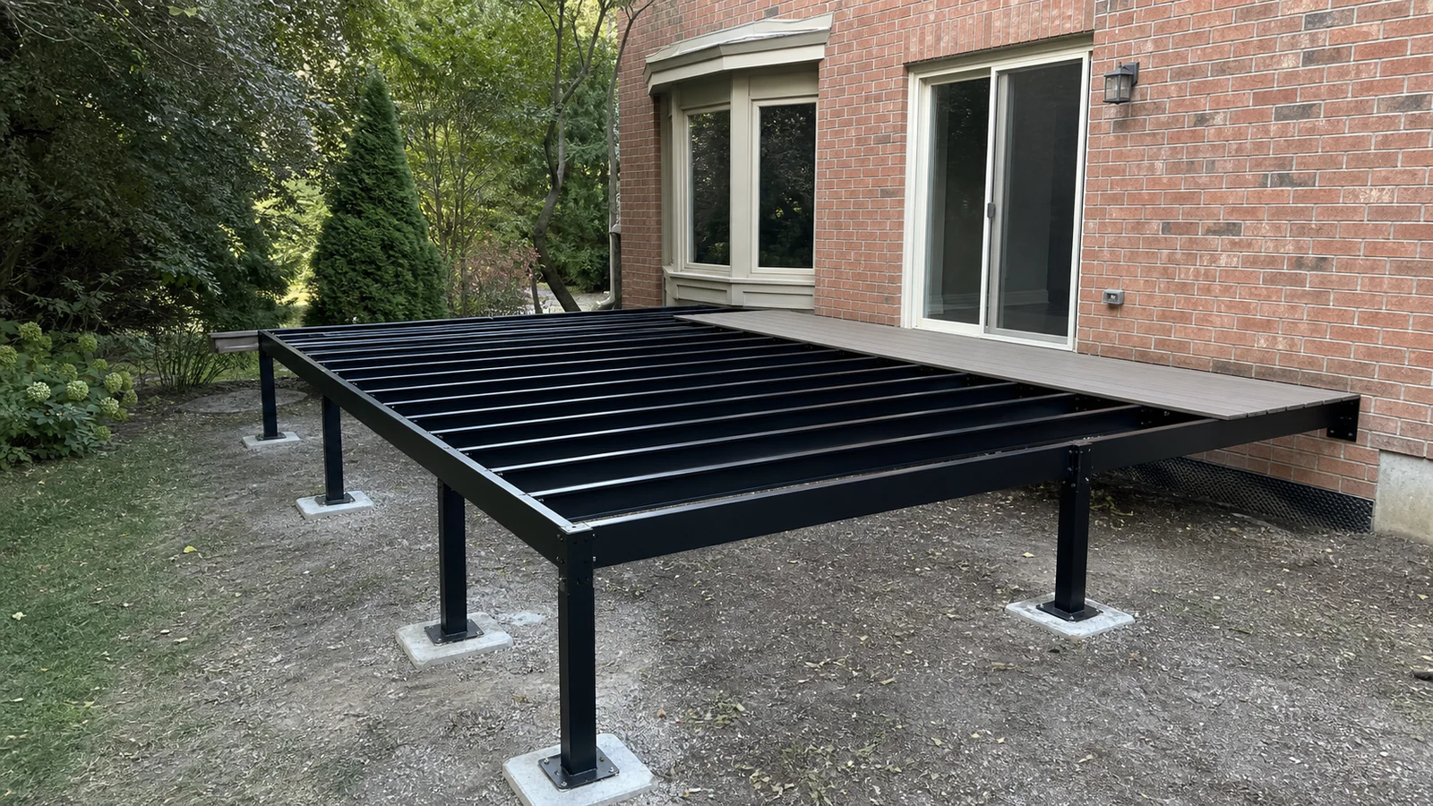 Straight black steel deck joists and beams installed behind a Greater Toronto Area brick home