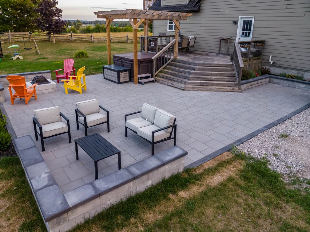 Elevated view of an Innisfil hardscape patio with separate fire-side and lounge seating zones