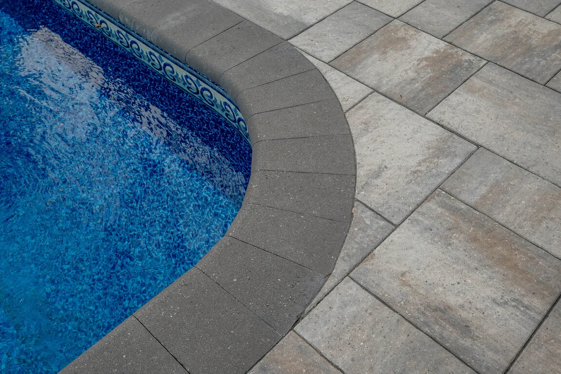 Close view of the curved interlock border around an existing vinyl liner pool in Schomberg