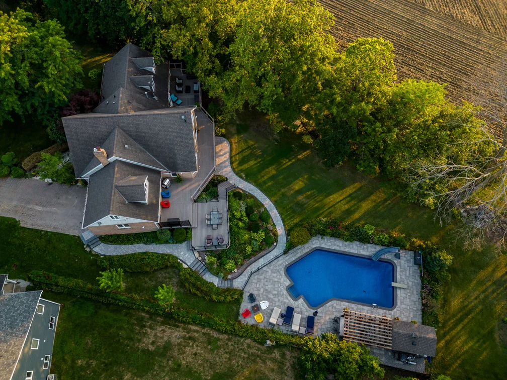 Aerial view showing a composite deck, curved stone walkway and existing backyard pool in Schomberg
