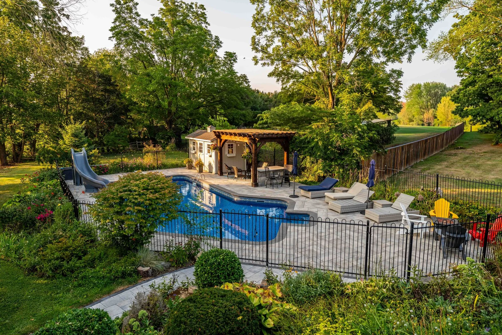 Existing pool with an interlock surround, landscaping and a deck connection at a Schomberg property