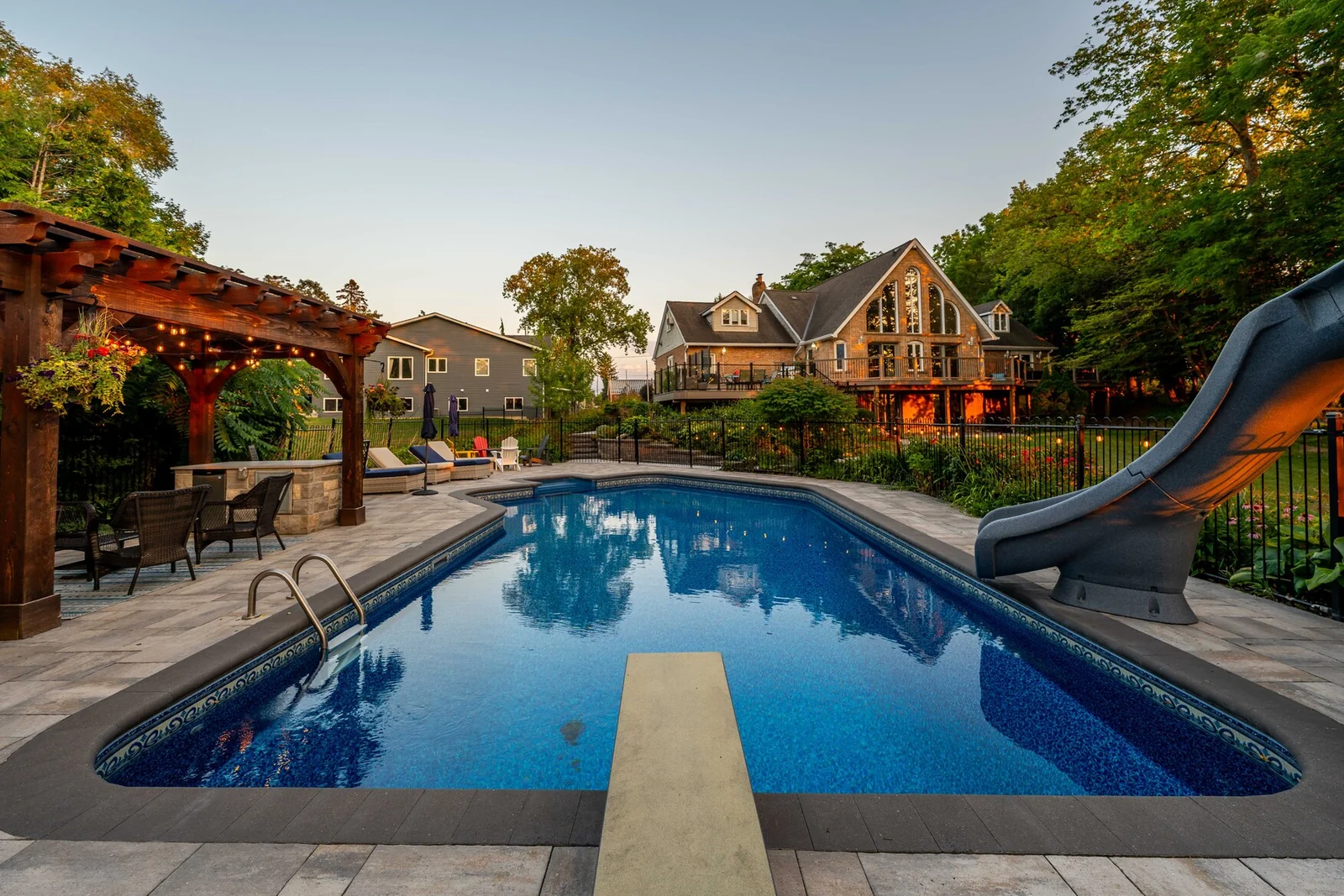 Existing backyard pool with an interlock patio, slide and shaded seating area in Schomberg