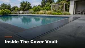 Automatic pool cover housing built into the edge of a backyard pool deck