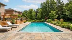 Backyard inground pool with stone patio in an Ontario yard